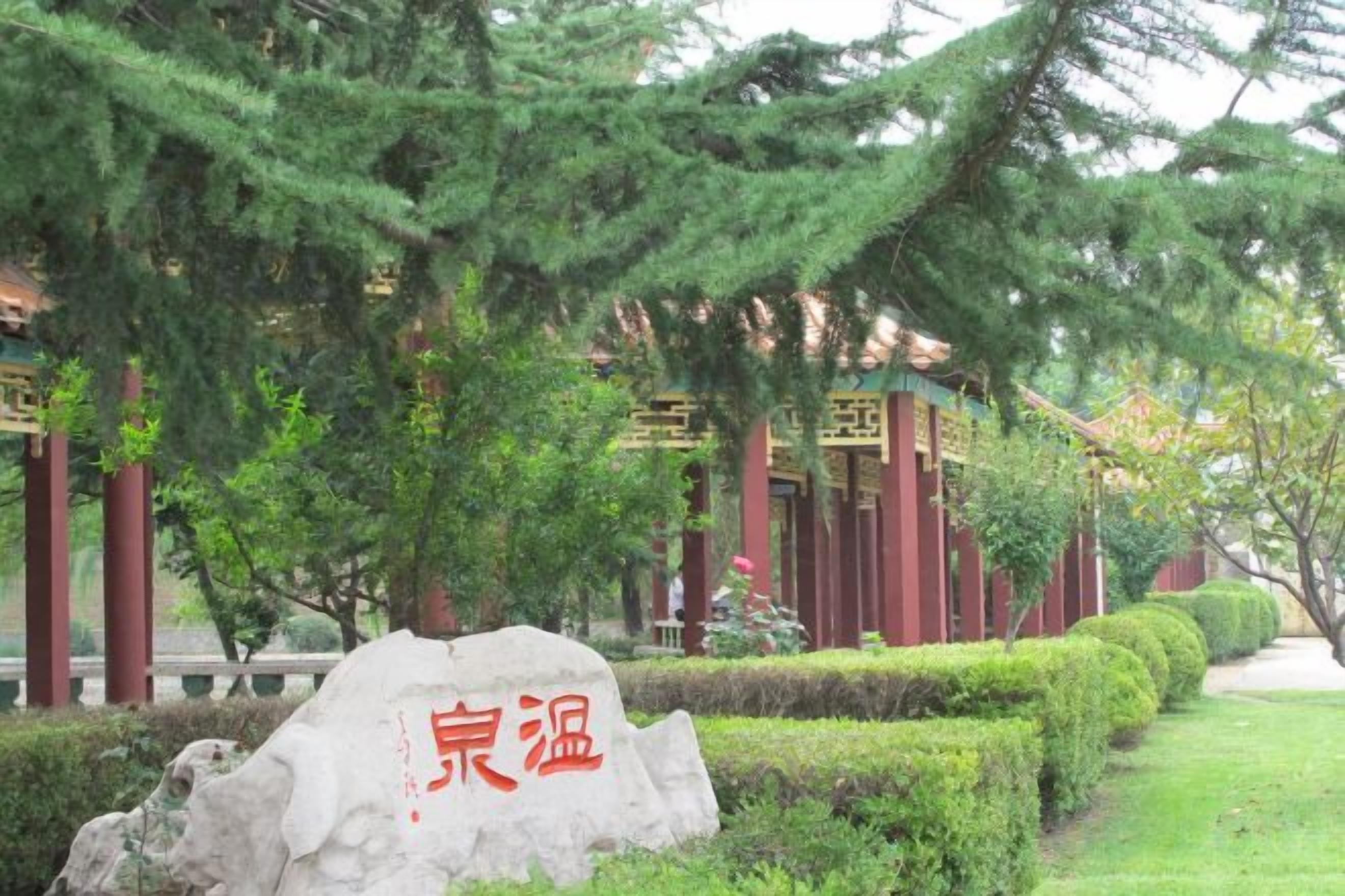 A traditional Chinese building with a stone marker in front.