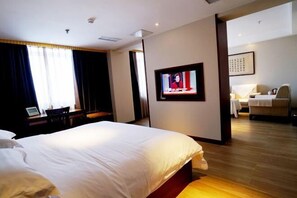 A hotel room with a large bed, a television on the wall, and a desk with a chair. - Jincheng Hot Spring Hotel (Zhaoyuan)