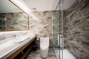 A modern bathroom with a marble wall, a glass shower enclosure, and a wooden vanity. - Jincheng Hot Spring Hotel (Zhaoyuan)