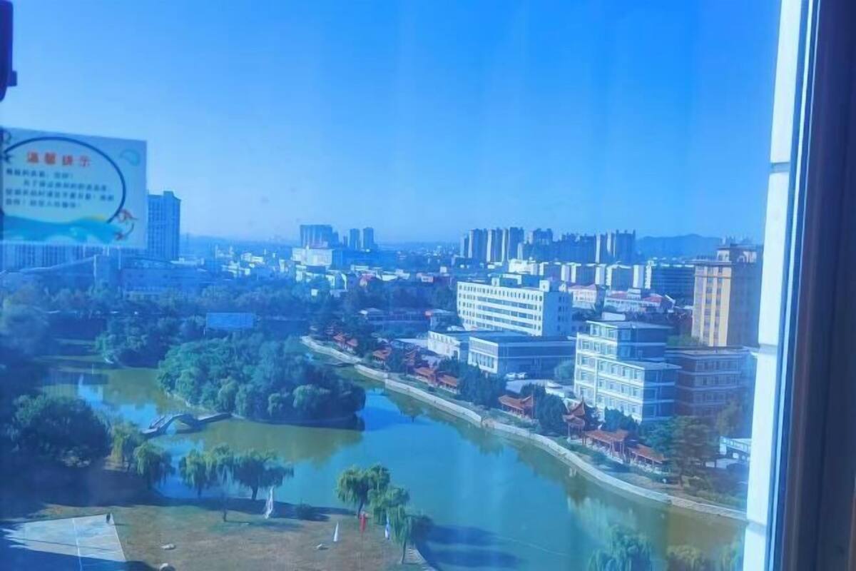 A cityscape with buildings, a river, and a signboard.