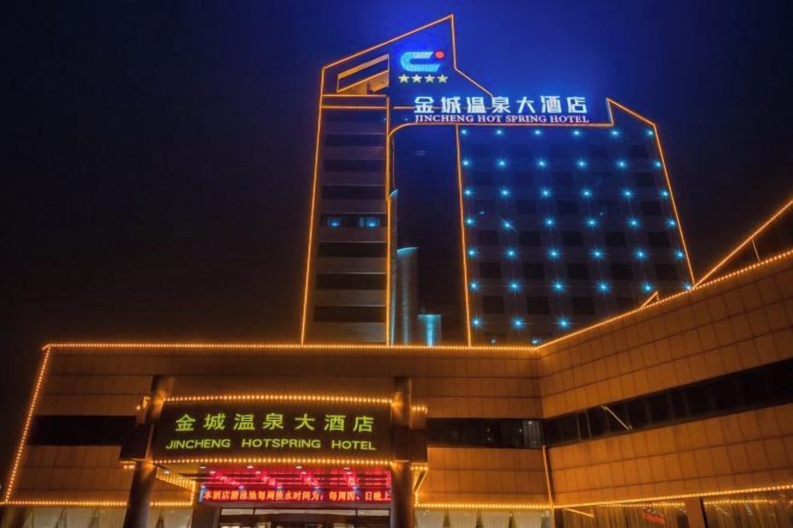 Un albergo con un cartello ben visibile e finestre illuminate di notte.
