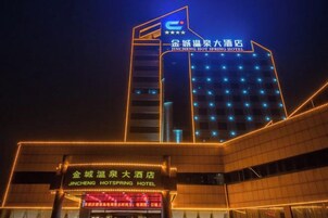 Un hotel con un letrero llamativo y ventanas iluminadas por la noche.