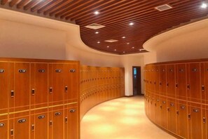 A hotel corridor with wooden lockers, a curved ceiling, and a recessed lighting fixture. - Jincheng Hot Spring Hotel (Zhaoyuan)