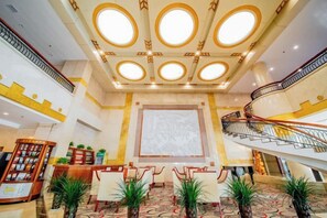 A hotel lobby with a grand staircase, a reception desk, and a large seating area. - Jincheng Hot Spring Hotel (Zhaoyuan)