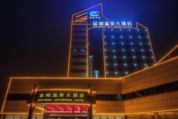 The Jincheng Hot Spring Hotel with a prominent sign and illuminated facade at night. - Jincheng Hot Spring Hotel (Zhaoyuan)