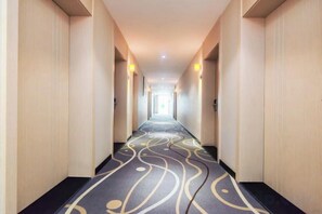 A hotel corridor with a patterned carpet, light-colored walls, and a ceiling with recessed lighting. - 7 Days Premium. Chongqing Qijiang District Government Store (Chongqing)