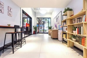 A hotel lobby with a reception desk, seating area, and bookshelves. - 7 Days Premium. Chongqing Qijiang District Government Store (Chongqing)