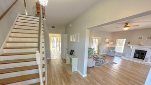 A spacious living area with a wooden staircase, a fireplace, and a dining area. - Peaceful property on the historic Suwannee River. (Bell)