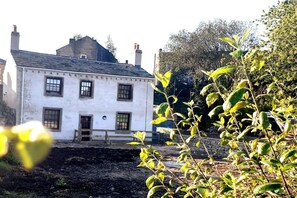 A white building with a gabled roof and multiple windows. - 1700s Canalside Cottage Sleeps up to 12 Guests (Burnley)