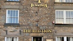 A stone building with the sign "Jennings The Red Lion" indicating a pub or restaurant. - The Red Lion (Sedbergh)