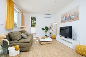 A modern living room with a sofa, a coffee table, a TV, and a painting on the wall. - Hedera Estate, Hedera A38 (Dubrovnik)