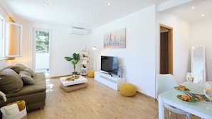 A modern living room with a sofa, TV, and dining area. - Hedera Estate, Hedera A38 (Dubrovnik)