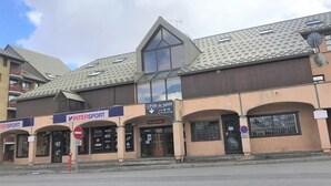 Een gebouw met verschillende etalages, waaronder een gezondheidscentrum en een sportzaak.