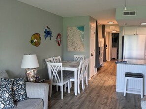 Un coin repas comprenant une table et des chaises, une lampe et des œuvres d’art murales.