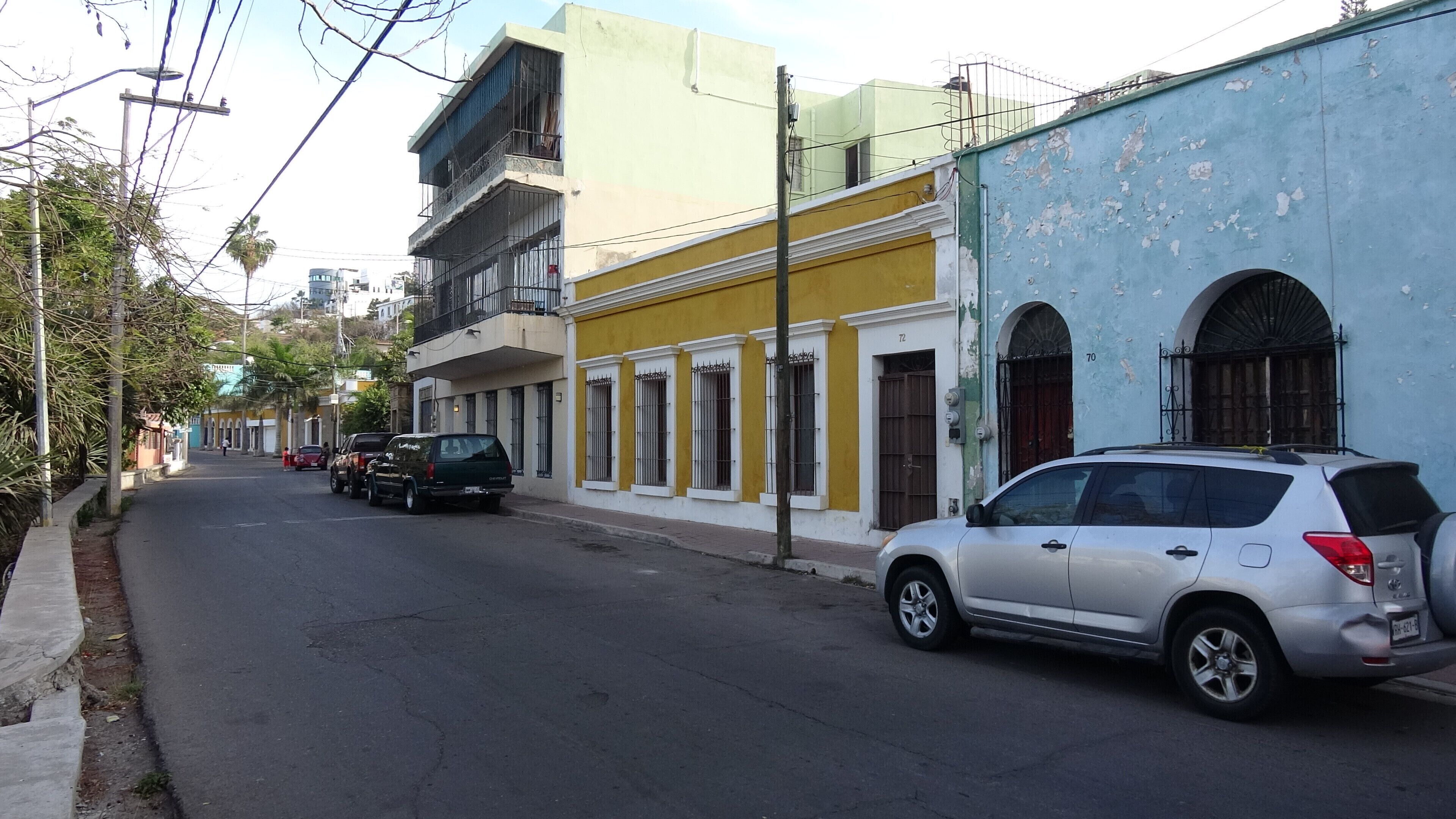 Una calle con coches aparcados y edificios.