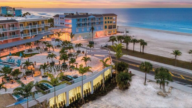 Rantahotelli, jossa on useita parvekkeita, uima-allasalue ja näkymä rannalle.