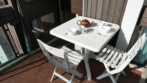 A white outdoor table and chairs with a teapot and cups on the table. - 2nd floor, balcony, parking, tv, ski locker, 25m², Saint Gervais (Saint-Gervais-les-Bains)