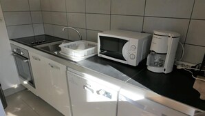 A compact kitchen with a dishwasher, microwave, and coffee maker. - 2nd floor, balcony, parking, tv, ski locker, 25m², Saint Gervais (Saint-Gervais-les-Bains)