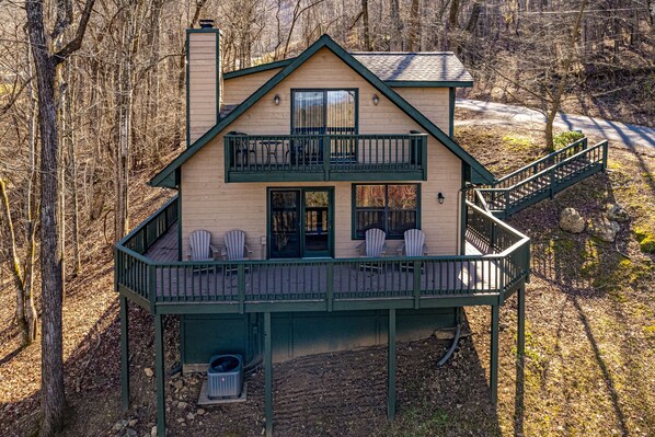 Relax on the spacious balcony with forest views, featuring a chimney and deck area.