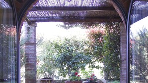 A patio with a table and chairs, a potted plant, and a view of greenery. - Romantic independent country house with garden, between Lucca and Florence (Toscana)
