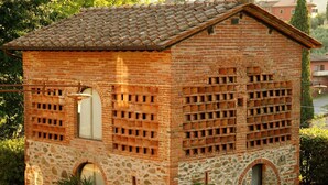 A small brick building with a tiled roof, stone walls, and multiple windows. - Romantic independent country house with garden, between Lucca and Florence (Toscana)
