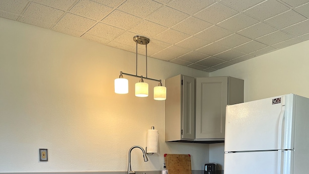 A compact kitchen with a central island, a white refrigerator, and a wooden countertop.