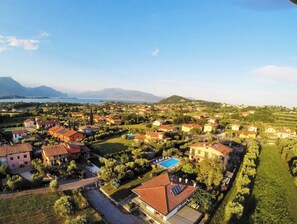 An aerial view of a residential area with houses, a swimming pool, and a mountain in the background.