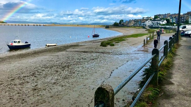 A beach with boats, a rainbow, and a coastal town in the background. - Crow's Nest (Carnforth)