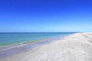 A beach with clear blue water and a sandy shore. - Blind Pass D204 (Sanibel)