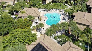 Ein Resort mit mehreren Gebäuden, einem zentralen Pool und üppiger Bepflanzung.