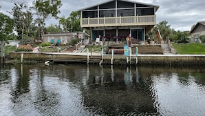 A two-story house with a balcony, a dock, and a garden. - SPECIAL DEAL! WATERFRONT•King & Queen Suites•3 Baths•Kayaks,SUP•Manatee,Dolphin (Weeki Wachee)
