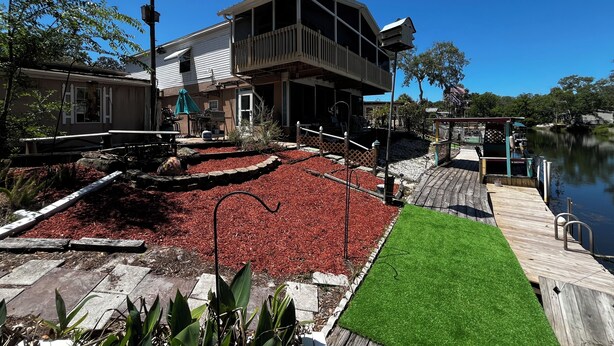 A two-story house with a deck, a dock, and a small garden area. - SPECIAL DEAL! WATERFRONT•King & Queen Suites•3 Baths•Kayaks,SUP•Manatee,Dolphin (Weeki Wachee)