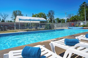 Una piscina al aire libre de temporada, sombrillas