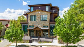 A multi-story building with a stone facade, large windows, and a covered front porch. - New Listing/Brand New Construction in the Heart of Downtown Whitefish (Whitefish)