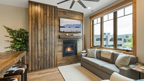 A cozy living room with a fireplace, a large window, and a view of the outside. - New Listing/Brand New Construction in the Heart of Downtown Whitefish (Whitefish)