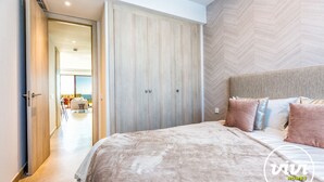 A bedroom with a large bed, a wardrobe, and a view of an outdoor seating area. - Blue View | sea view - garden - pool (Mijas Costa)
