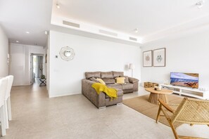 Una sala moderna con un sofá, una mesa de centro y un televisor.