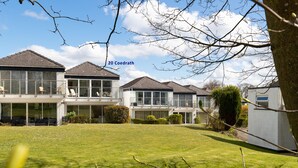 A residential area with modern houses, a well-maintained lawn, and a clear sky. - Calon Y Mor - Close to Village and Beach (Saundersfoot)