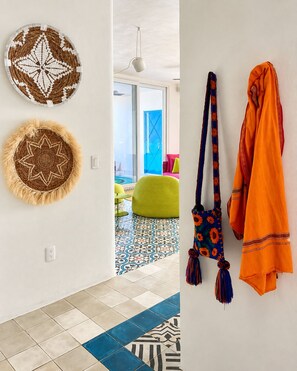 Una habitación con suelo estampado, una silla verde y una puerta azul.