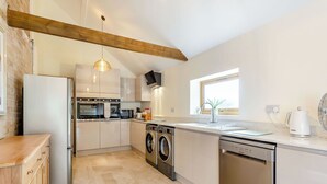 A modern kitchen with a built-in oven, microwave, and dishwasher. - Tawny Acre Barn - UK38614 (South Walton Highway, Wisbech)