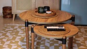 Deux tables en bois, chacune surmontée d’un set de table en fibres tressées et d’une télécommande.