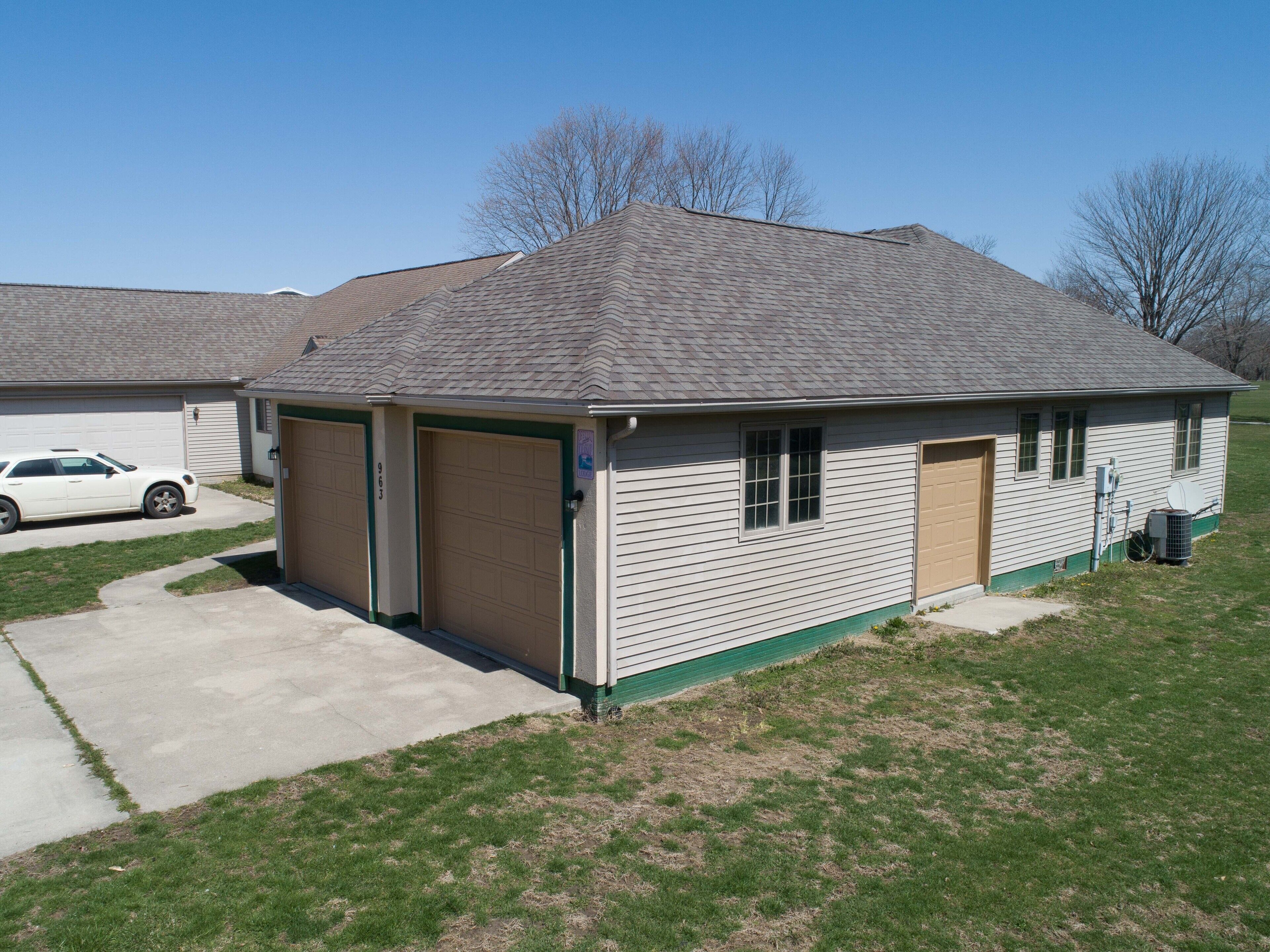 A single-story building with two garage doors, a small attached structure, and a satellite dish.