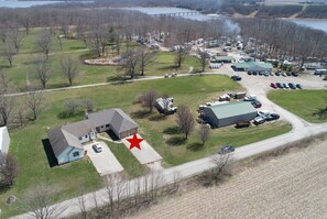 An aerial view of Lake Shelbyville with RVs, a large building, and a bridge in the background.
