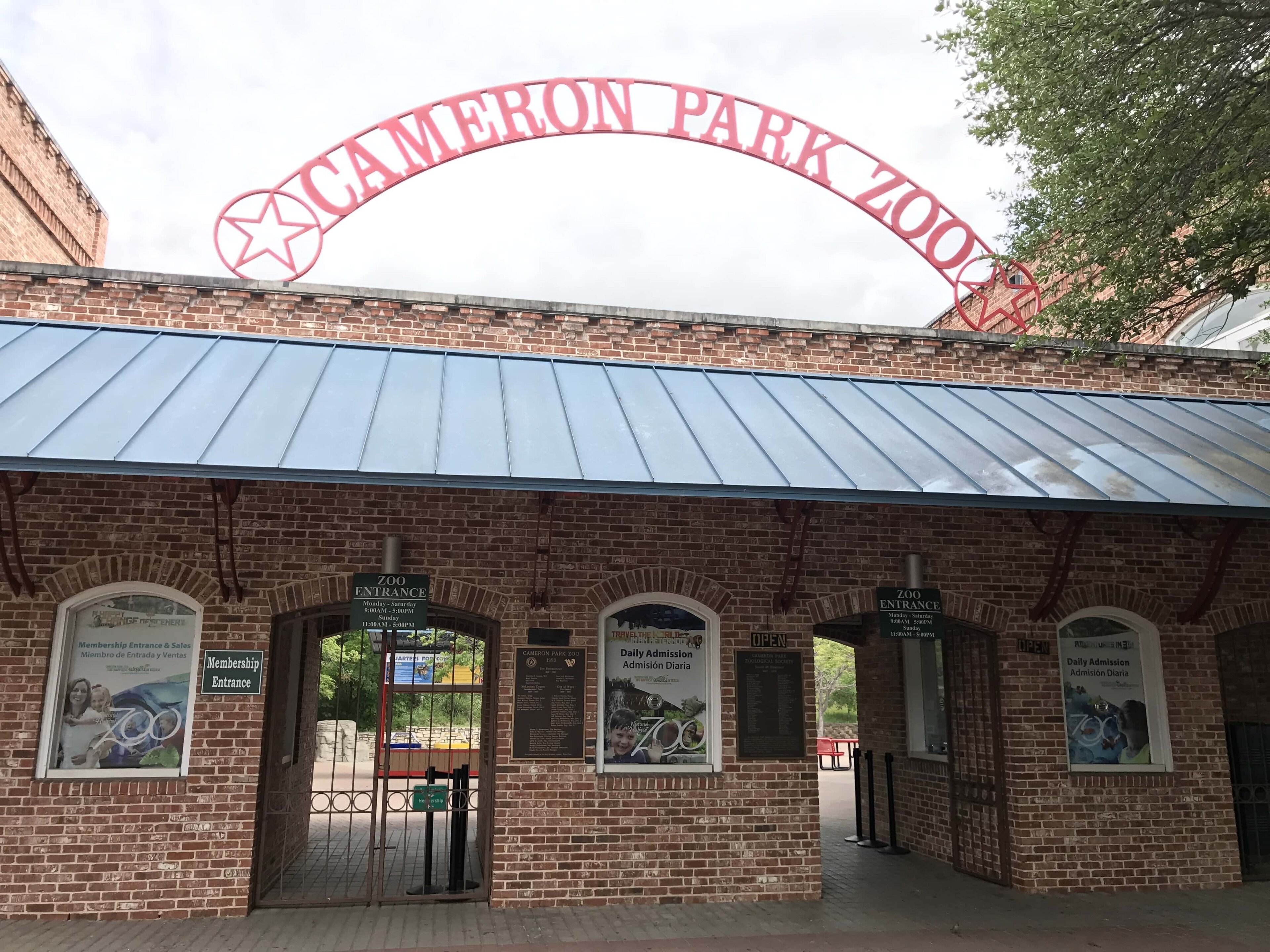 Tiilestä rakennettu rakennus, jonka suuri, kaareva sisäänkäynti on koristeltu kyltillä, jossa lukee: »CAMERON PARK ZOO».