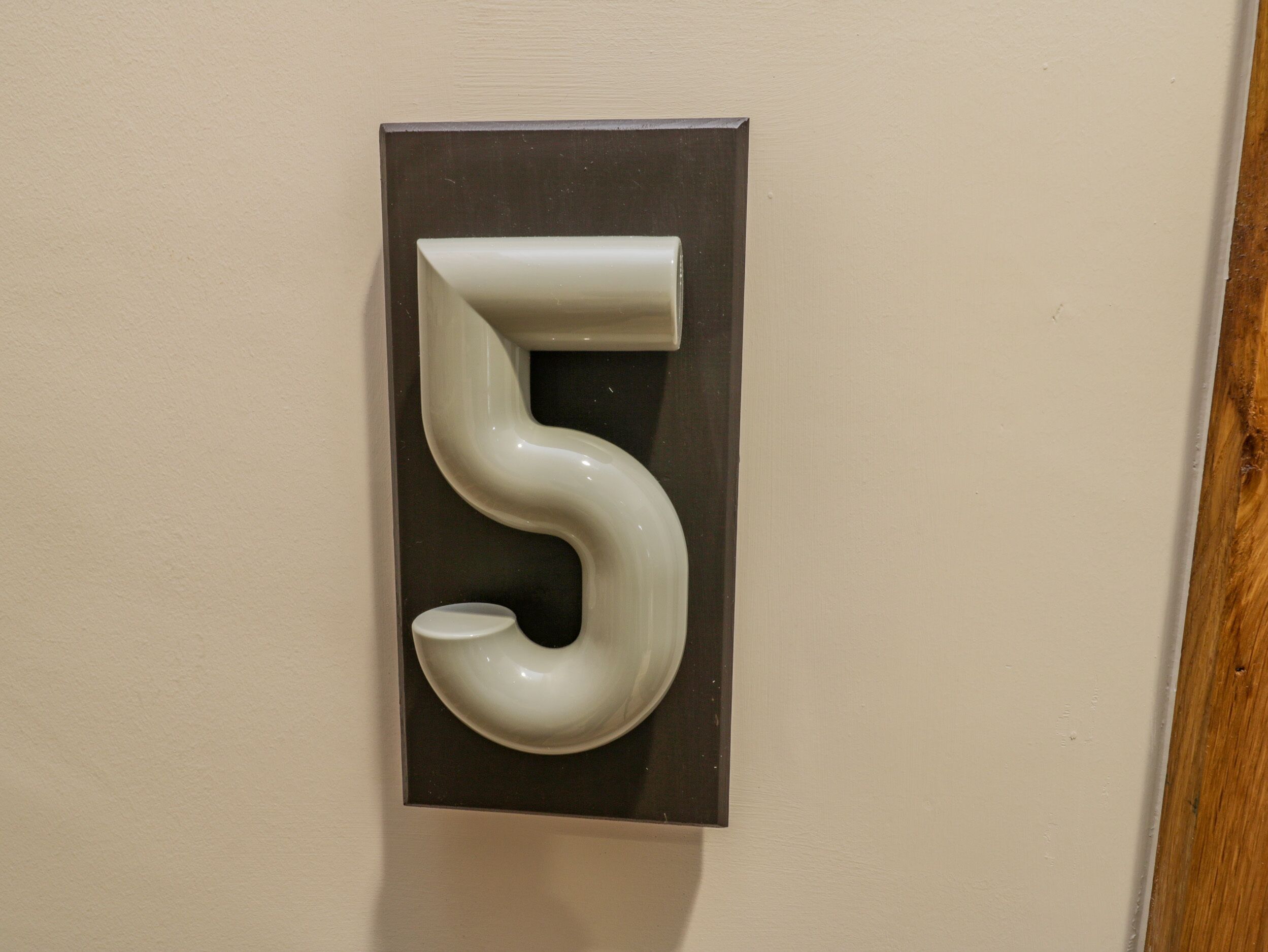 A wall-mounted number '5' sign.