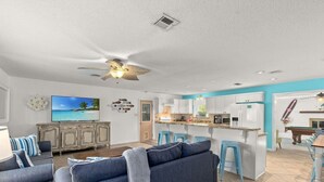 A modern living room with a sofa, TV, and a ceiling fan.