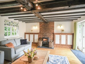 Una sala de estar acogedora con chimenea, un sofá y una mesa de centro.