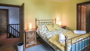 A bedroom with a bed, bedside tables, a lamp, and a wooden door. - 6 bedroom accommodation in Dorrington, near Church Stretton (Dorrington, near Church Stretton)