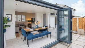 A modern kitchen with a dining area, a sliding glass door leading to a patio, and a view of the backyard. - 3 bedroom accommodation in Rhyl and Prestatyn (Rhyl and Prestatyn)