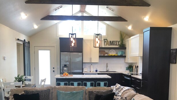 A cozy living room with a sectional sofa, a coffee table, and a patterned rug. - Eagle's Nest - Beautiful House close to boat launch and local attractions.  (Russellville)